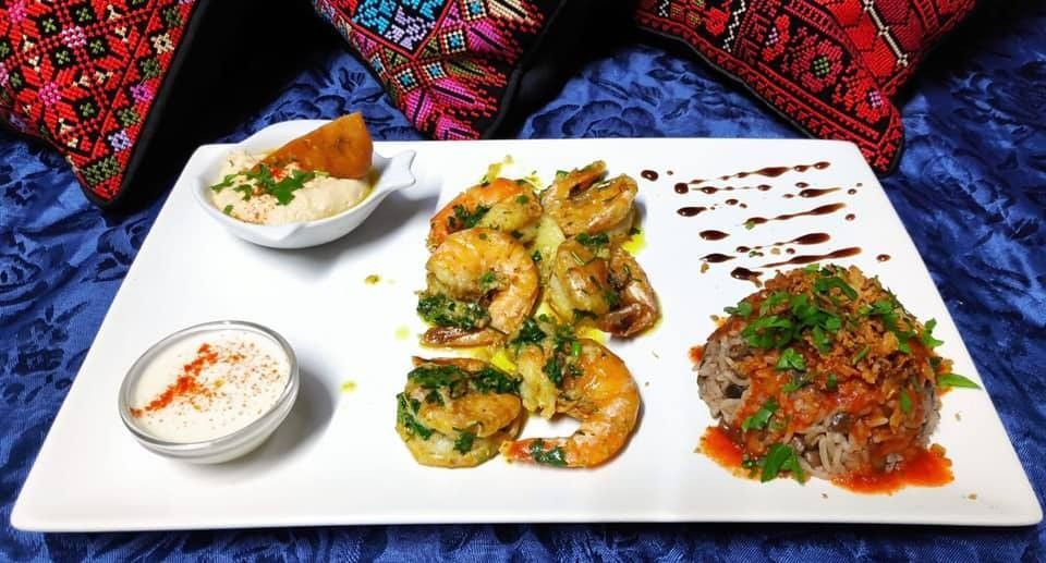 Assiette de scampis sautés à l'ail et à la coriandre, hummus et mojadara